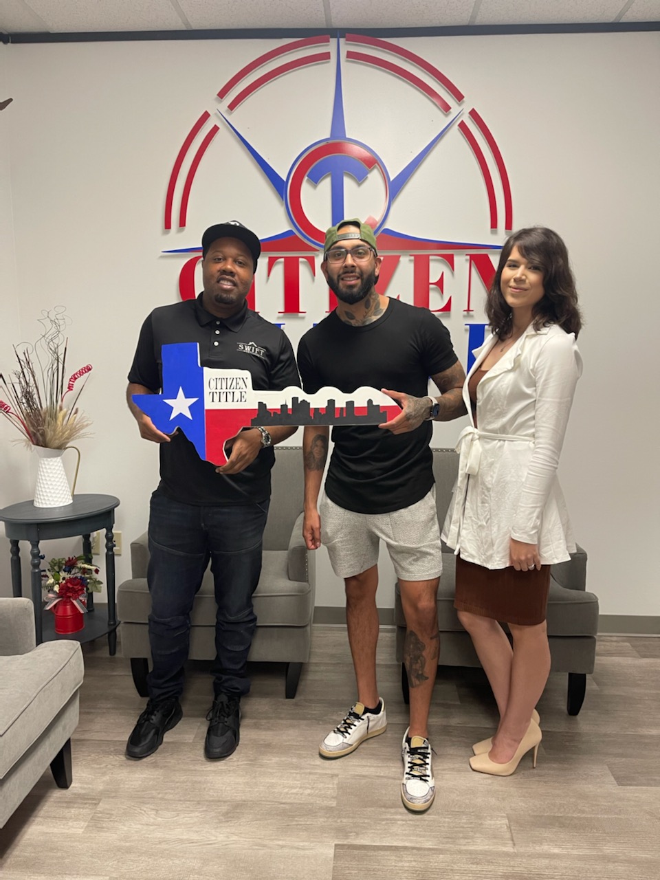 Marlon Wilson with clients holding a Texas-shaped key after a home closing.